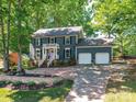 Charming home featuring a two-car garage, brick walkway, manicured lawn, and traditional design at 10024 Whitethorn Dr, Charlotte, NC 28277
