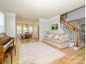 Cozy living room with a view into the dining room, featuring hardwood floors and a staircase at 10944 Persimmon Creek Dr, Mint Hill, NC 28227