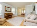 An inviting living room with a piano, hardwood floors, and a view into the dining room at 10944 Persimmon Creek Dr, Mint Hill, NC 28227