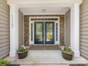 Inviting front entrance with decorative glass double doors and stone accents at 11727 Dunham Dr, Matthews, NC 28105