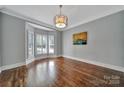 Spacious living room featuring hardwood floors, a decorative chandelier, and a bright bay window at 128 Spears Creek Dr, Mooresville, NC 28117