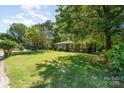 Quaint single-story brick home with an expansive grassy front lawn shaded by mature trees at 1301 Burnwick Ct, Charlotte, NC 28213