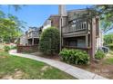 Attractive townhouse with private balconies, a brick facade, and lush green landscaping at 1608 Sharon W Rd # 55, Charlotte, NC 28210