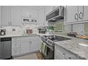 Updated kitchen featuring granite countertops, modern stainless steel appliances, and sleek white cabinetry at 1608 Sharon W Rd # 55, Charlotte, NC 28210