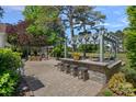Inviting outdoor kitchen has stone countertops, bar seating, grill and fireplace for outdoor entertaining at 17924 River Ford Dr, Davidson, NC 28036
