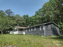Comfortable single-story home with a covered porch, surrounded by lush trees and ample yard space at 1820 Trinity Church Rd, Monroe, NC 28112