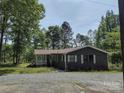 Charming home featuring a covered porch and is nestled among mature trees at 1820 Trinity Church Rd, Monroe, NC 28112