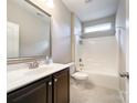 A well-lit bathroom features a shower-tub, dark vanity, and ample counter space at 1876 Yellow Daisy Dr, Matthews, NC 28104