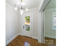 Bright foyer with hardwood floors, a modern light fixture, coat closet and a door with glass window to the outside at 1909 Summey Ave, Charlotte, NC 28205
