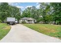 Expansive view of this single-story home, with a long driveway, recreational vehicle parking, and wooded surround at 195 Kings Ter, Salisbury, NC 28146