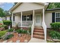 Close-up of the front porch with brick steps and white railings, surrounded by colorful flower beds at 195 Kings Ter, Salisbury, NC 28146