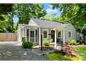 Quaint home featuring a landscaped front yard, inviting entrance, and driveway, surrounded by lush trees at 2008 Highland St, Charlotte, NC 28208