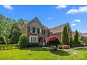 Well-maintained brick home with a manicured lawn and mature trees at 2025 Groves Edge Ln, Waxhaw, NC 28173
