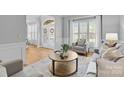 Bright living room with a round coffee table, neutral furniture, and large windows at 2025 Groves Edge Ln, Waxhaw, NC 28173