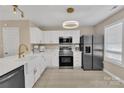 Bright kitchen with white cabinets, stainless appliances, quartz counters, and modern lighting at 3127 Ocalle Ln, Indian Land, SC 29707