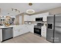 Modern kitchen featuring white cabinets, stainless steel appliances, and stylish lighting at 3127 Ocalle Ln, Indian Land, SC 29707