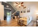 Bright living room with vaulted ceiling, wood floors, ceiling fan, and open staircase at 3412 Summerfield Ridge Ln, Matthews, NC 28105