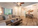 Inviting living room with dining area, wood floors, neutral decor, and lots of sunlight at 3412 Summerfield Ridge Ln, Matthews, NC 28105
