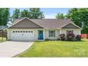 Attractive home with a well-kept lawn, a two-car garage, and a vibrant blue front door at 5057 Sedgefield Dr, Lancaster, SC 29720