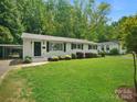 Inviting home featuring a well-maintained lawn, complemented by a convenient carport enhancing functionality and curb appeal at 5219 Farmbrook Dr, Charlotte, NC 28210