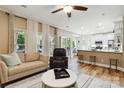 An open living room features hardwood floors, a ceiling fan, and seamless flow to kitchen at 7700 Ninth Fairway Ln, Mint Hill, NC 28227