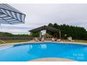 Sparkling in-ground pool with shaded lounge area, perfect for outdoor relaxation and entertainment at 7740 Freeze Rd, Kannapolis, NC 28081
