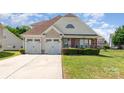 Charming two-story home featuring an attached two-car garage, manicured lawn, and stone-accented porch at 9588 Marquette Nw St, Concord, NC 28027