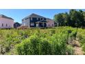 A lush green backyard behind a two-story home featuring a covered patio at 1001 Cunningham Farm Dr, Indian Trail, NC 28079