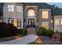 Beautiful home entrance showcasing stone and brick facade, double doors, and manicured landscaping at 1001 Medinah Ct, Waxhaw, NC 28173