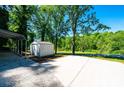 Long concrete driveway with a carport and storage shed in a wooded area at 1018 Autumn Ln, Hickory, NC 28602