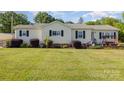 Inviting single-story home with a well-maintained lawn and a relaxing front porch swing at 106 Rainbow Sw St, Concord, NC 28025