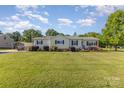 Well-kept home featuring a manicured lawn, charming exterior details, and a porch swing at 106 Rainbow Sw St, Concord, NC 28025