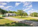 Spacious home with a long gravel driveway, a large lawn, and mature trees at 106 Rainbow Sw St, Concord, NC 28025