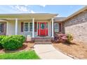 Charming covered front porch with red front door, brick steps, and manicured landscaping at 110 Carol Lyn Dr, Kings Mountain, NC 28086