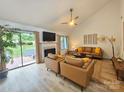 Bright living room with modern furniture, fireplace, and sliding glass doors to the backyard at 11216 Carmel Chace Dr, Charlotte, NC 28226