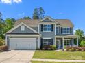 Traditional two-story home with gray siding, black shutters, white garage door, and manicured landscaping at 11931 The Ramble Dr, Huntersville, NC 28078