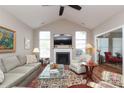 Cozy living area with vaulted ceiling, fireplace, hardwood floors, and comfortable sofas at 2114 N Castle Ct, Matthews, NC 28105