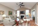 Bright living room features vaulted ceiling, fireplace, hardwood floors, and a ceiling fan at 2114 N Castle Ct, Matthews, NC 28105