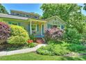 Inviting home with lush landscaping, a brick walkway, and quaint blue shutters at 2115 Mecklenburg Ave, Charlotte, NC 28205