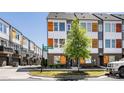 Exterior shot of modern townhomes with brick and siding, complemented by landscaped greenery and street signage at 2123 Bryant Park Dr, Charlotte, NC 28208