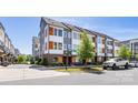 Street view of modern townhomes with gray and white siding, and well-maintained landscaping and street signage at 2123 Bryant Park Dr, Charlotte, NC 28208