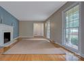 Bright living room with hardwood floors, a fireplace, and large windows at 2235 Ramblewood Ln, Charlotte, NC 28210