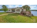 Exterior elevation view of home with green lawn and lake in background at 235 River Loop Rd, Belmont, NC 28012