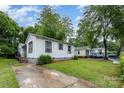 Home with white siding, featuring a well-maintained lawn and concrete driveway at 2622 Hemphill St, Charlotte, NC 28208