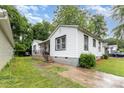Charming white home with dark trim, showcasing a quaint yard and inviting front porch at 2622 Hemphill St, Charlotte, NC 28208