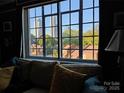 Bright living room with a large window offering views of the city skyline and lush greenery. For sale by Canopy MLS 2025 at 301 W 10Th W St, Charlotte, NC 28202