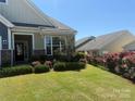 Well-manicured front yard with flowering shrubs, lush grass, and a charming exterior at 309 Kentmere Ln, Clover, SC 29710