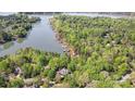 Scenic aerial view of lakefront homes surrounded by lush greenery and tranquil waters at 3508 Mountain Cove Dr, Charlotte, NC 28216