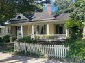 This property features a charming yellow exterior, enhanced by a white picket fence and lush landscaping at 500 W Council St, Salisbury, NC 28144