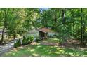 Inviting single story home surrounded by lush greenery and mature trees for added privacy at 7357 Elwood Dr, Charlotte, NC 28227